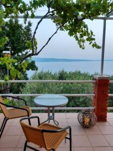 einen Tisch und Stühle auf einer Terrasse mit Meerblick in der Unterkunft Holiday Home Betty in Jesenice