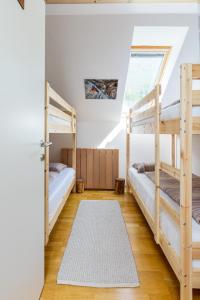 a bedroom with two bunk beds and a door at Alpine Base Kranjska Gora in Kranjska Gora