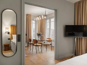 a bedroom with a mirror and a dining room at Ad Astra by Elite - Hotel, Spa & Resort in Södertälje