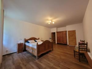 1 dormitorio con 1 cama y suelo de madera en Pałac Heymanna - Oficyna, en Ścibórz