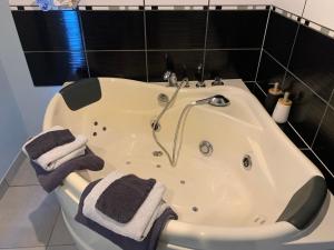 a bathroom with a bath tub with towels on it at Dépendance chaleureuse et calme in Champagneux