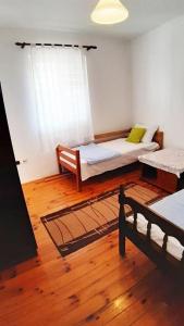 um quarto com duas camas e um banco em Joli apartaments Kumbor em Kumbor