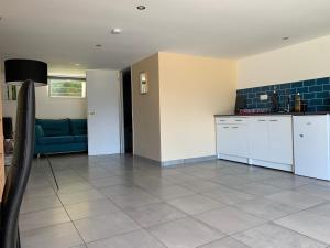 a kitchen and living room with a blue couch at Dépendance chaleureuse et calme in Champagneux