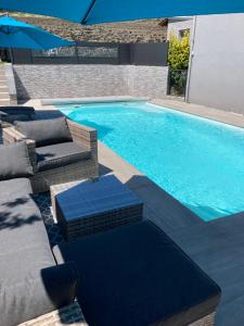 a swimming pool with wicker chairs and a swimming pool at Le clos des Arvernes in Corent