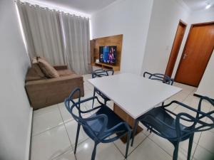 a living room with a table and chairs and a couch at TH Flats GV in Governador Valadares