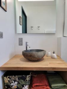 ein Badezimmer mit einem Steinwaschbecken auf einer Holztheke in der Unterkunft Air marin in La Bernerie-en-Retz