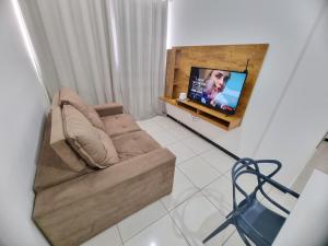 a living room with a couch and a flat screen tv at TH Flats GV in Governador Valadares