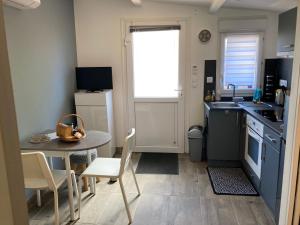 a small kitchen with a table and a table and chairs at Le clos des Arvernes in Corent