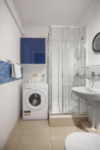 a bathroom with a washing machine and a sink at Sleepy3city with Sea View II in Gdynia