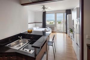 a kitchen with a sink and a living room at Sleepy3city with Sea View II in Gdynia
