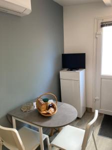 mesa y sillas en una habitación con TV en Le clos des Arvernes, en Corent