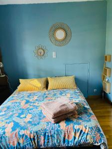 een slaapkamer met een bed met een blauwe muur bij Maison provençale in Six-Fours-les-Plages