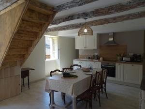 une cuisine avec une table et des chaises dans une pièce dans l'établissement Domaine avec piscine à Milhac dans le Lot 4 étoiles 2 gîtes, à Milhac