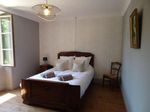 une chambre avec un lit avec des draps blancs et un lustre dans l'établissement Domaine avec piscine à Milhac dans le Lot 4 étoiles 2 gîtes, à Milhac 40 autres photos