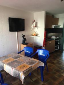 a room with a table and two chairs and a tv at T2 rez de jardin Saint Pierre la mer in Fleury +1 photo