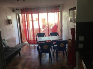 a dining room with a table and chairs and a window at T2 rez de jardin Saint Pierre la mer in Fleury