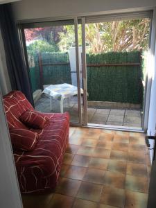 a living room with a couch and a sliding glass door at T2 rez de jardin Saint Pierre la mer in Fleury