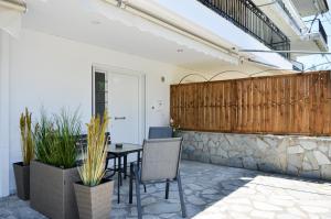 a patio with a table and chairs and a fence at Holistic Stay in Avia