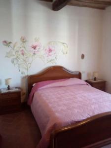 a bedroom with a bed with flowers on the wall at Casa nella roccia in Roccastrada