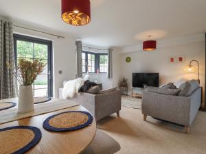 a living room with two couches and a table at 9 Oaks Court in Leiston