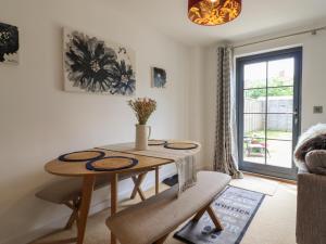 a living room with a table and chairs and a window at 9 Oaks Court in Leiston