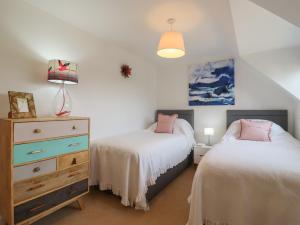 a bedroom with two beds and a dresser at 9 Oaks Court in Leiston