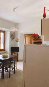 a kitchen and dining room with a table and a refrigerator at Casa nella roccia in Roccastrada