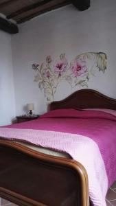 a bedroom with a pink bed with a floral headboard at Casa nella roccia in Roccastrada