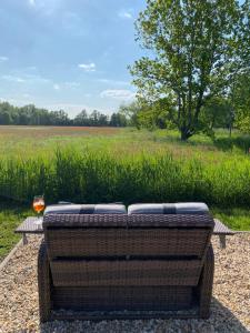 a wicker couch sitting on a table in front of a field at Deichappartement-Brüggen in Brüggen