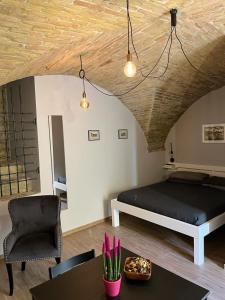 een slaapkamer met een bed, een stoel en een tafel bij Al Miracolo in Lanciano