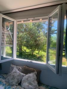 a window in a room with two pillows on a couch at Maison BelleMondo in Criel-sur-Mer