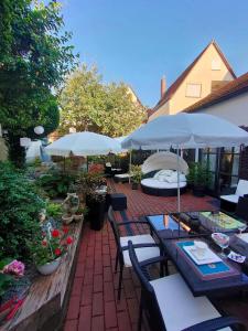 een patio met tafels, stoelen en parasols bij Gästehaus Engelgasse Herzogenaurach in Herzogenaurach