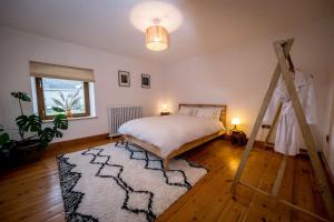 1 dormitorio con cama y alfombra en Water and Wildwood - The Bothy Cottage en Muff