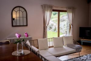 uma sala de estar com um sofá branco e uma janela em Water and Wildwood - The Bothy Cottage em Muff