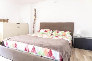 une chambre avec un grand lit avec des oreillers colorés dans l'établissement Smiley House By Case al Lago, à San Felice del Benaco