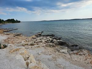 a large body of water with rocks on the shore at Apartments Dora Victoria Dream in Medulin