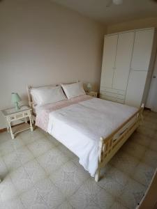 1 dormitorio con 1 cama grande y 2 mesas en Casa dei miei, en Sperlonga