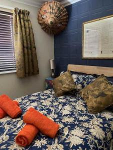 a bedroom with a blue and white bed with pillows at Bryn Castell, Conwy in Conwy