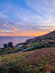 パンテレリアにあるDammuso Eurus, oasi di relax a Pantelleriaの夕日の丘から海の景色を望めます。