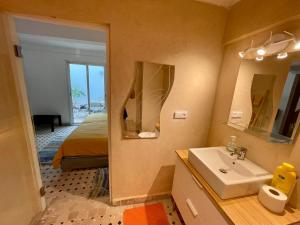 Un baño con lavabo, cama y espejo. en Au Riad des Deux Patios - Marrakech, en Marrakech 79 fotos más