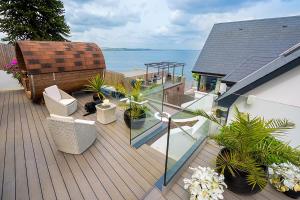 a deck with plants and chairs on a house at NEWCASTLE stunning sea views & forest backdrop in Newcastle