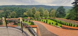 einen Gehweg, der zu einem Garten mit Büschen und Bäumen führt in der Unterkunft Villa Florencia in Bardejov