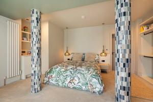 ein Schlafzimmer mit einem Bett und zwei großen Säulen in der Unterkunft NEWCASTLE stunning sea views & forest backdrop in Newcastle