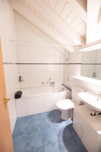 ein Badezimmer mit einem Waschbecken, einem WC und einer Badewanne in der Unterkunft Blumenstrasse 22 in Interlaken