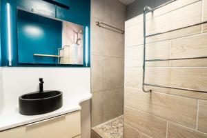 a bathroom with a sink and a glass shower at coconut beach citerne in Le Gosier +9 photos