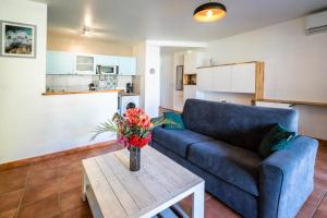 a living room with a blue couch and a table at coconut beach citerne marisol in Le Gosier +4 photos