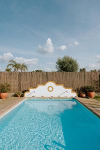 a swimming pool in front of a wooden fence at Monte Além Tejo in Arraiolos