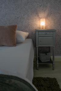 łóżko ze stolikiem nocnym ze świecą w obiekcie Le Dejoux - Appartement avec terrasse en centre ville w mieście Vichy