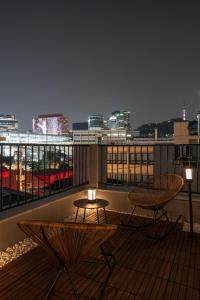 a balcony with two tables and a view of the city at Koon Terrace Stay in Seoul