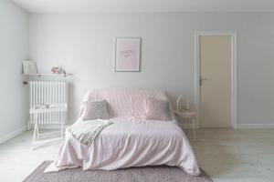 biała sypialnia z łóżkiem z różowym kocem w obiekcie Le Dejoux - Appartement avec terrasse en centre ville w mieście Vichy